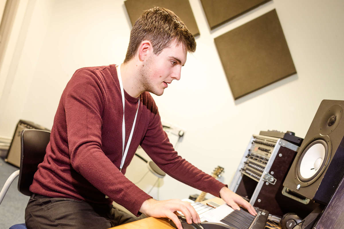 a young male playing the keyboard