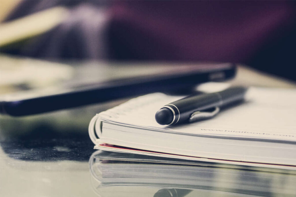 a pen and phone on top of a diary