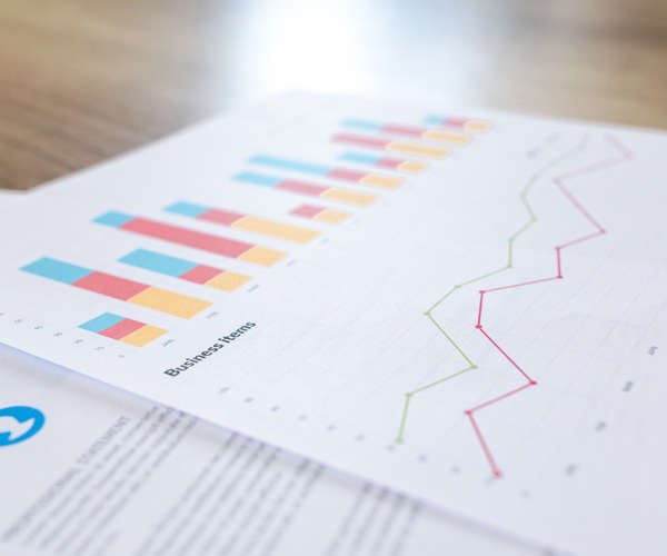 A bar chart and financial graph on white paper