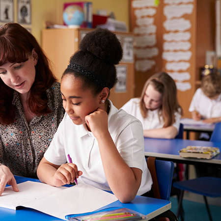 A woman with a child teaching her in a classroom