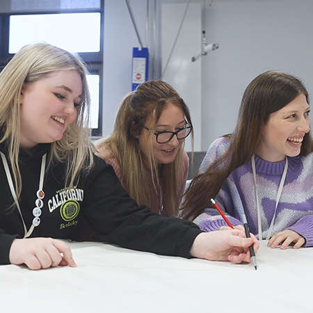 a young group of female students sat laughing